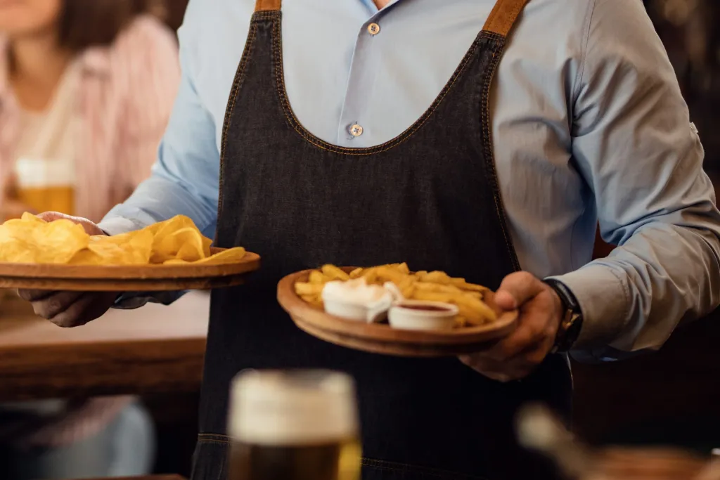 Happy Waiter Holding Plates With Food Looking Camera While Serving Guests Restaurant Scaled (1)