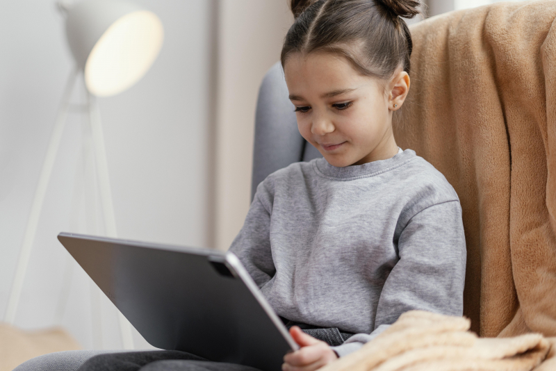 Little Girl Couch Using Tablet